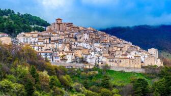 Die Stadtansicht Castel del Monte in einer grünen Landschaft im Nationalpark in Gran Sasso