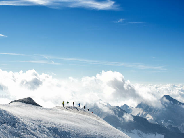 Hochtourengruppe auf verschneitem Bergrücken