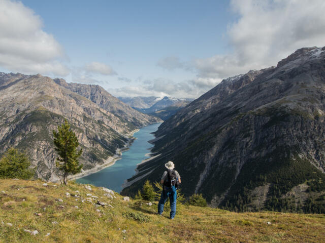 Wanderer mit Blick auf Bergsee in Livigno