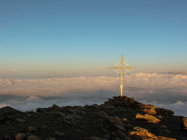 Sonnenaufgang am Gipfelkreuz in Sarntal