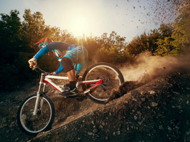 MTB Downhill auf Schotter bei Sonnenuntergang