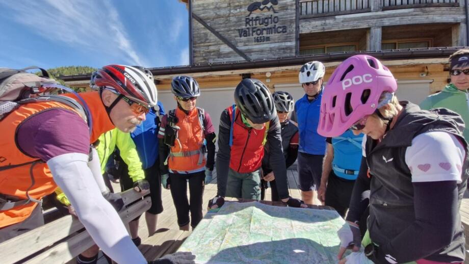 Eine Mountainbike-Gruppe unterwegs auf einer Tour. Sie sind gerade an der Tourenplanung.