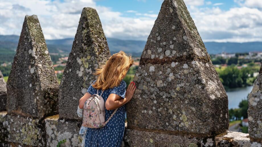 Touristin mit einem Rucksack genießt die Aussicht auf Tui von der Kathedrale Santa Maria