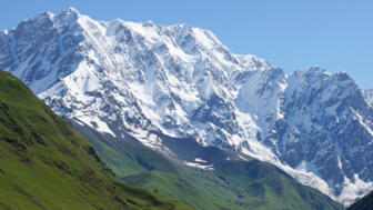 Vergletscher Fünftausender Schchara vor grünem Almgelände in Georgien