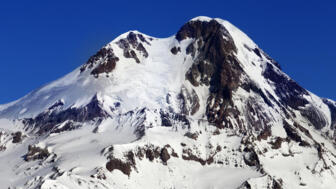 Verschneiter Gipfel des Fünftausenders Kasbek vom georgischen Wintersportort Gudauri aus gesehen