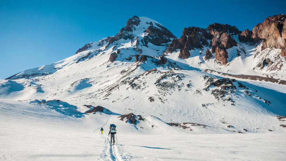 Zwei Skibergsteiger*innen im Aufstieg zur Bethlemi-Hütte am Fünftausender Kasbek in Georgien