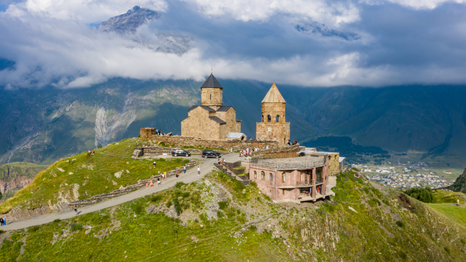 Luftansicht auf die Dreifaltigkeitskirche Gergeti und wolkige Berglandschaften