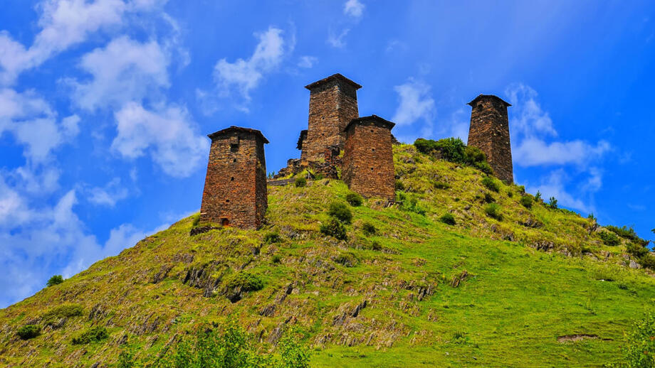 Grüner Hügel mit alten tuschetischen Wehrtürmen in Georgien