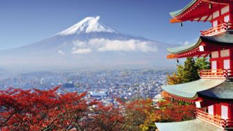 Blick von einer Pagode in Tokiyo über die Dächer der Stadt auf den Vukan Fuji mit seiner weißen Eiskappe