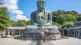 Riesige Stgatue eines Sitzenden Buddha in einem Tempel-Innenhof in Japan