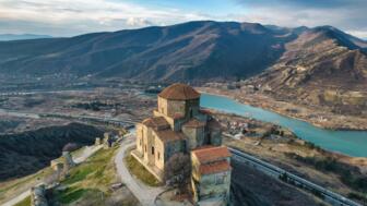 Kloster Jvari iin Georgien mit Sicht auf Fluss und braunes Hütelland