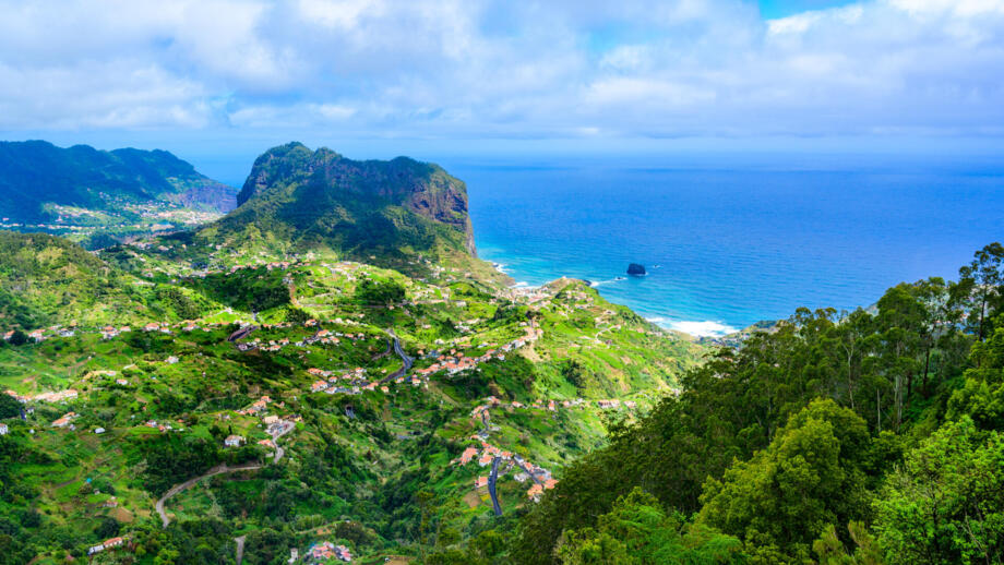 Felskegelan der Küste Madeira mit blauem Meer und grünem Hinterland
