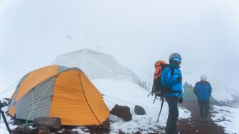 Hachlagerzelt und Bergsteiger*in am  Chimborazo