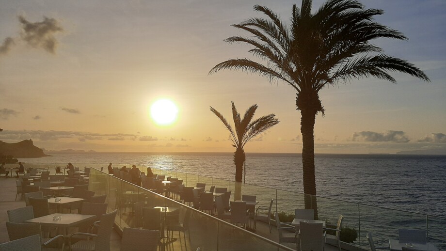 Sonnenuntergang von der Terrasse des Hotels Roca Mar mit Palmen und Blick auf das Meer