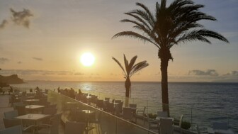Sonnenuntergang von der Terrasse des Hotels Roca Mar mit Palmen und Blick auf das Meer