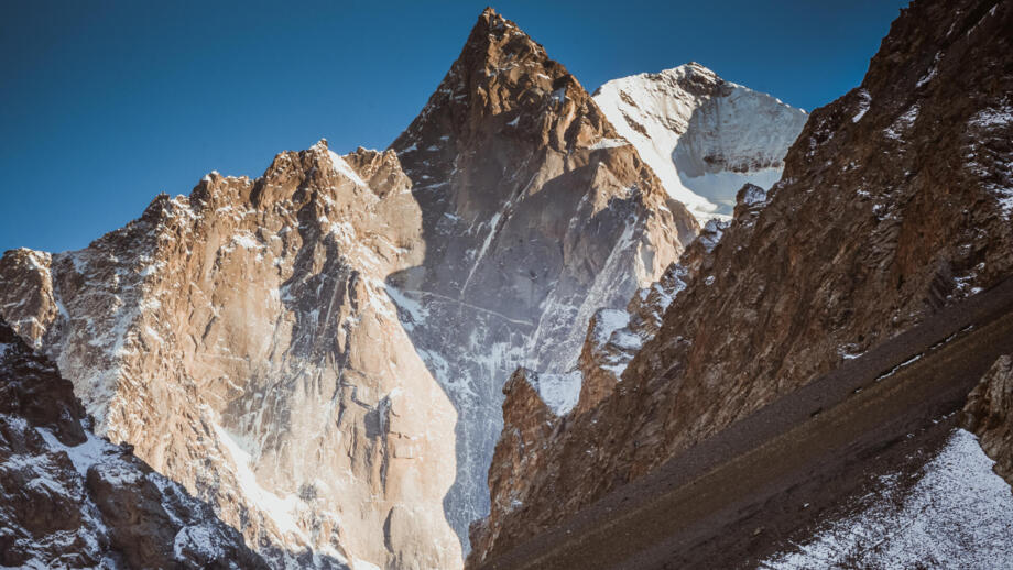 Aksu Peak: Tausend Meter hohe Granitwände unter EisgipfelnFelsiger Aksu Peak in der Turkestan Range vor eisbedecktem Gipfel