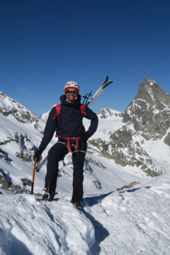 Bergführer Bernhard Hampel mit Ski auf dem Rücken am Gipfel