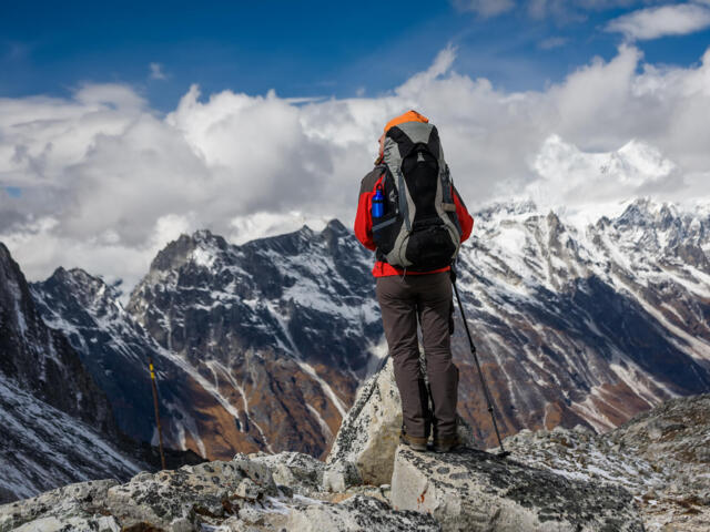 Blick von hinten auf einen Wanderer, der beim Abstieg des Larkya Passes ist