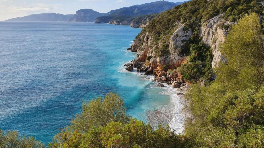 Luftaufnahme von einem felsigen Berg in Richtung schönem blauem Meer