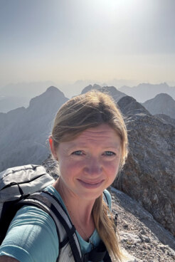 Bergwanderführerin Kristin Brinckmann auf einem Bergkamm bei strahlendem Sonnenschein