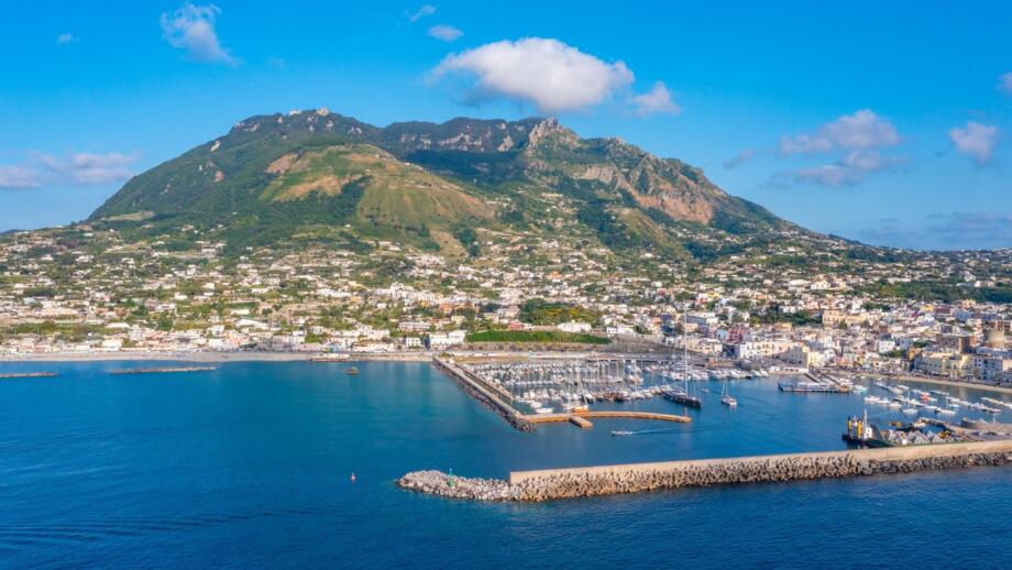 Der Berg Monte Epomeo über der italienischen Stadt Forio am Hafen auf der Insel Ischia