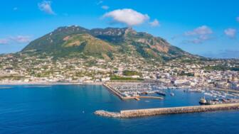 Der Berg Monte Epomeo über der italienischen Stadt Forio am Hafen auf der Insel Ischia
