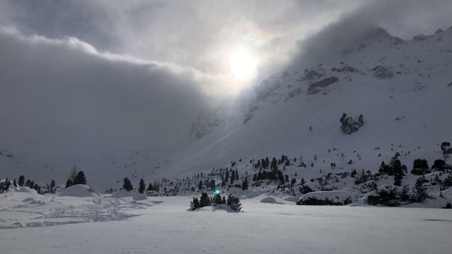 Blick auf die Sonne von der Lizumer Hütte aus, die durch die Wolken blitzt.