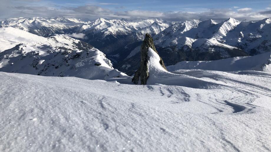 Schneeverwehungen vor dem Panorama der schneebedeckten Tuxer Alpen