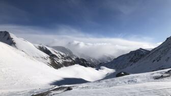 Bergpanorama mit Wolken, blauem Himmel und Schnee