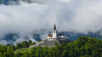 Eine Burg im Nebel in den Julischen Alpen.