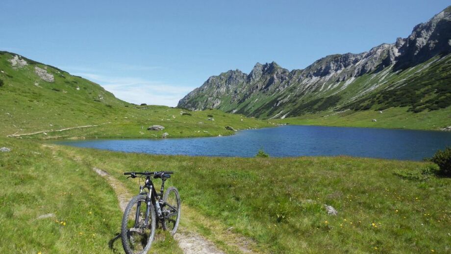 Ein Mountainbike auf der Route von Radtstadt nach Weißensee am See mit den Bergen im Hintergrund.