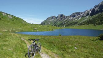 Ein Mountainbike auf der Route von Radtstadt nach Weißensee am See mit den Bergen im Hintergrund.