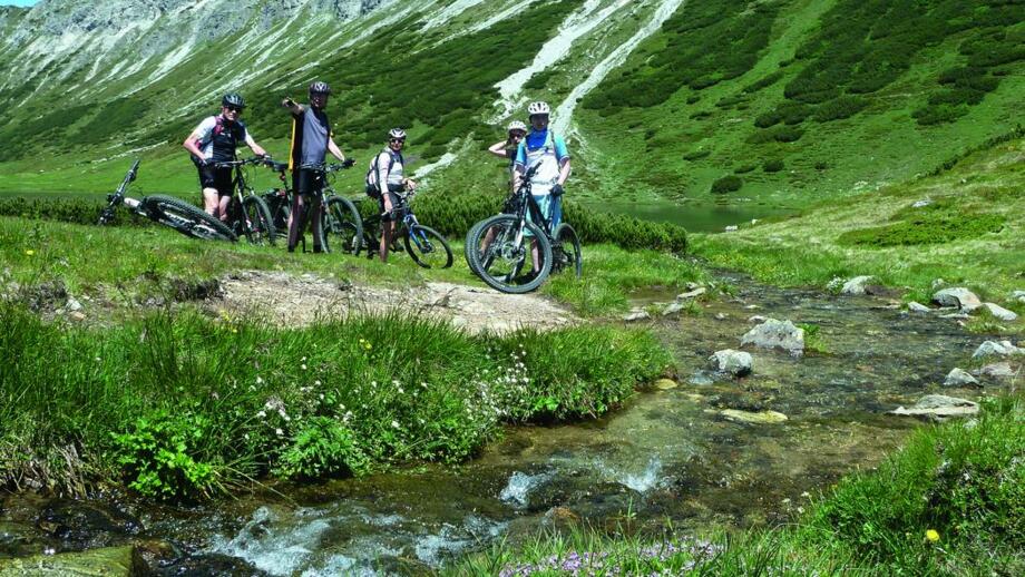 Eine Gruppe an Mountainbiker*innen auf der Tour von Radstadt nach Weißensee.