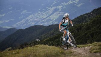 Ein*e E-Mountainbiker*in im Anstieg auf der Tour im Allgäu.