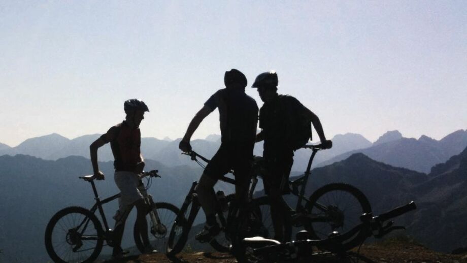 Eine Gruppe an E-Biker*innen mit Bergpanorama im Allgäu.