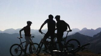 Eine Gruppe an E-Biker*innen mit Bergpanorama im Allgäu.