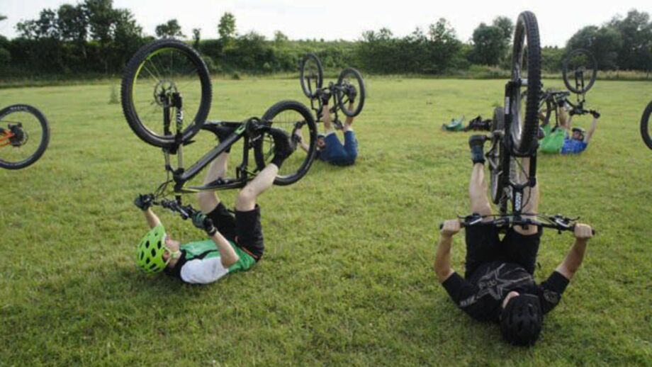 Mountainbiker*innen beim Fahrtechniktraining bei einer Übung auf einer Wiese