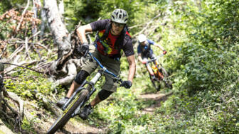 Eine Gruppe von Mountainbiker*innen auf einem Single Trail durch den Wald in Slowenien.