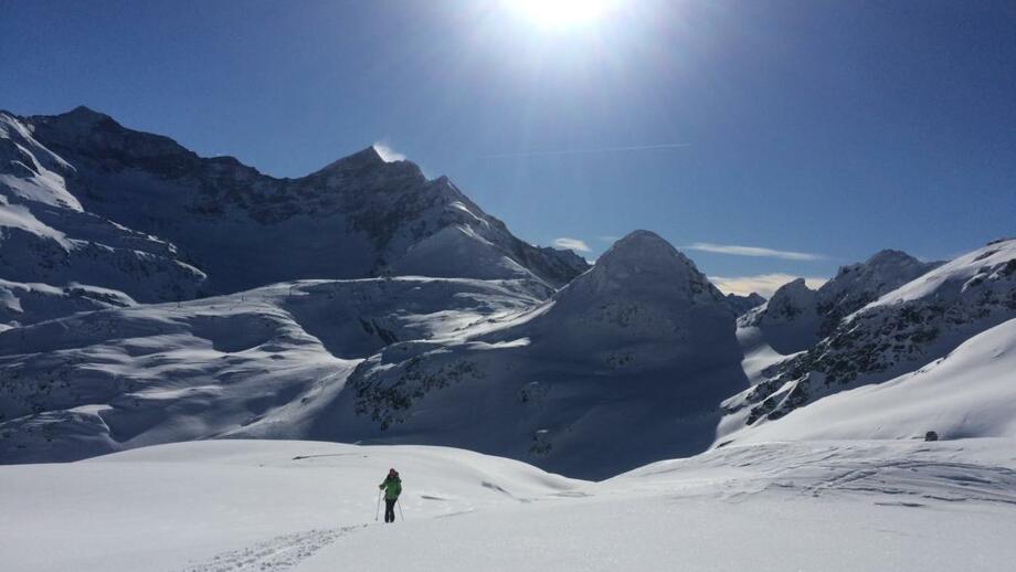 Skitourengeher mit Gipfelpanorama im Hintergrund