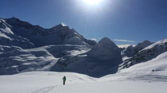 Skitourengeher mit Gipfelpanorama im Hintergrund