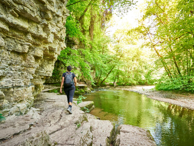 Wanderin am Wasser entlang auf dem Schluchtensteig bei Herbststimmung