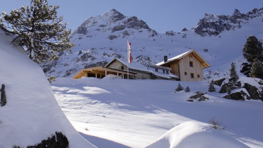 Außenansicht der schneebedeckten Hütte bei der Durchquerung