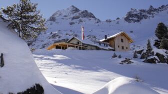 Außenansicht der schneebedeckten Hütte bei der Durchquerung