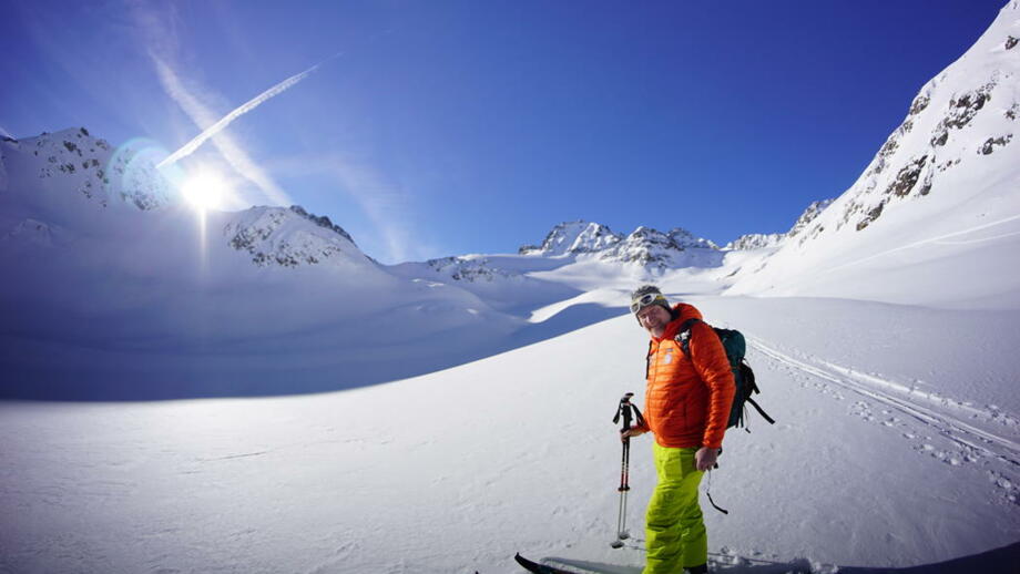 Summit Club Bergführer mit Bergpanorama bei blauem Himmel