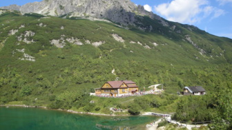 See und Bergpanorama mit Hütte im Hintergrund
