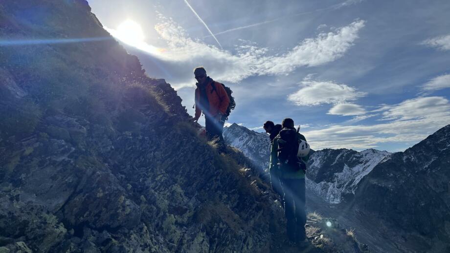 Zwei Bergsteiger auf Fels mit Sonne im Hintergrund