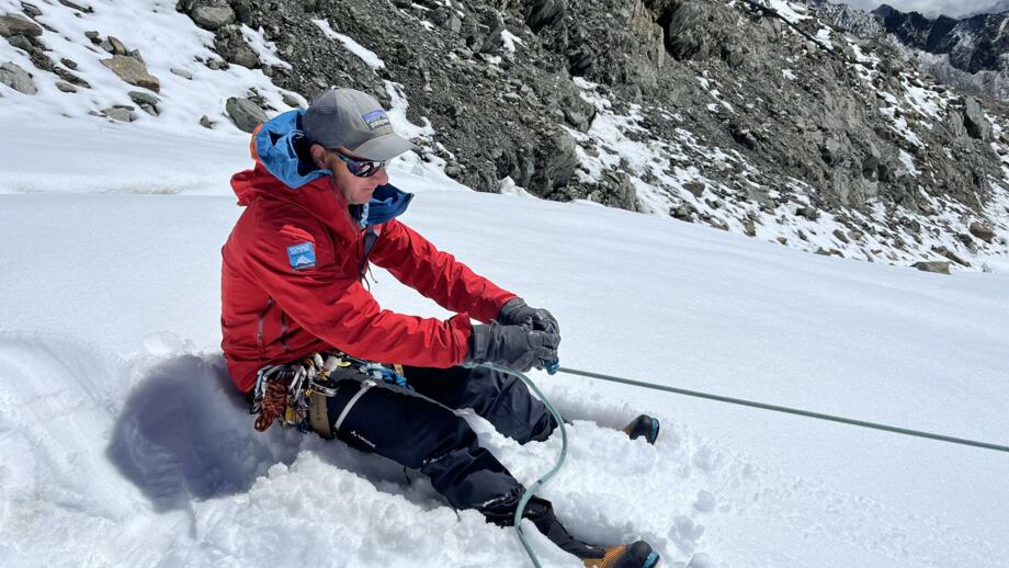 Ausbildungsinhalte Demonstration von Bergführer auf Schneefeld mit Pickel