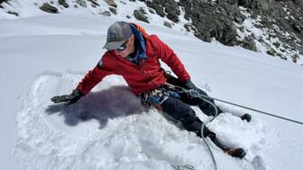 Ausbildungsinhalte Demonstration von Bergführer auf Schneefeld mit Pickel