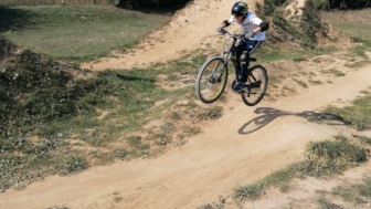 Junger Mountainbiker in der Abfahrt auf einem Single Trail.