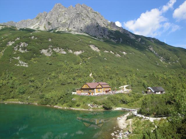 See mit herrlichem Bergpanorama und Hütte im Hintergrund
